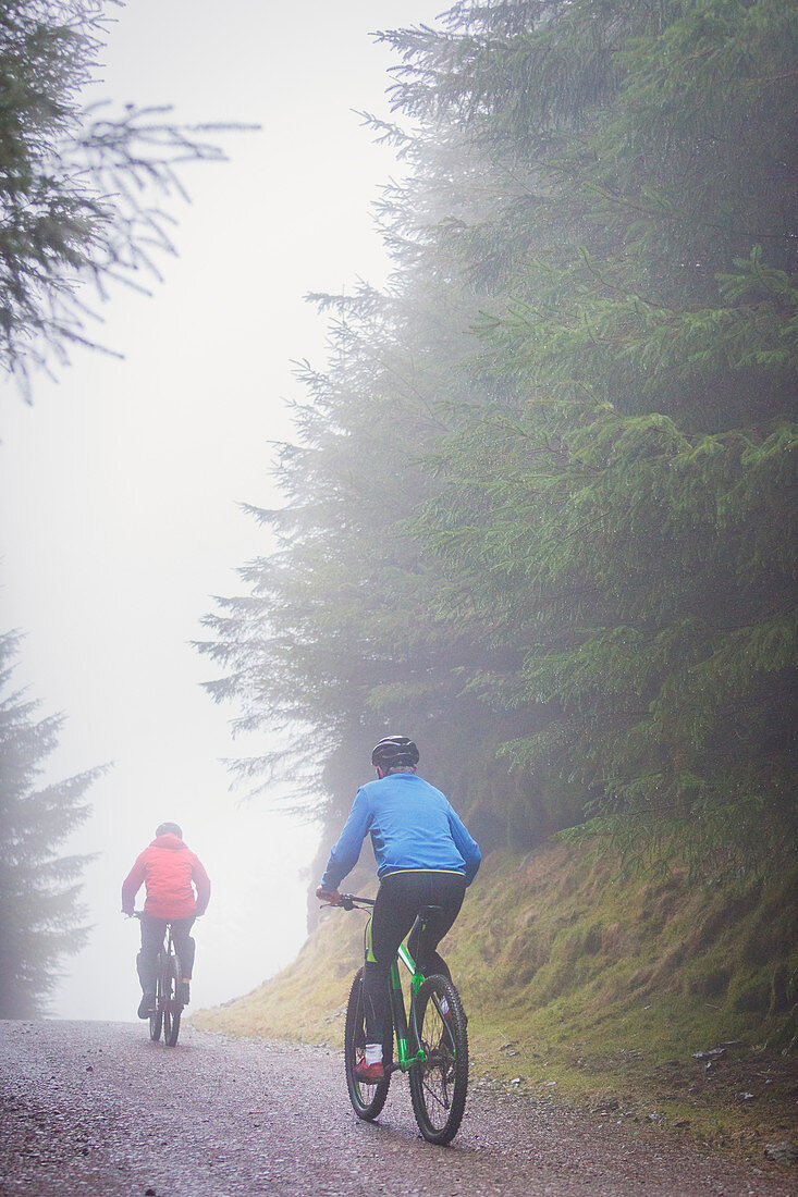 Couple mountain biking in rain