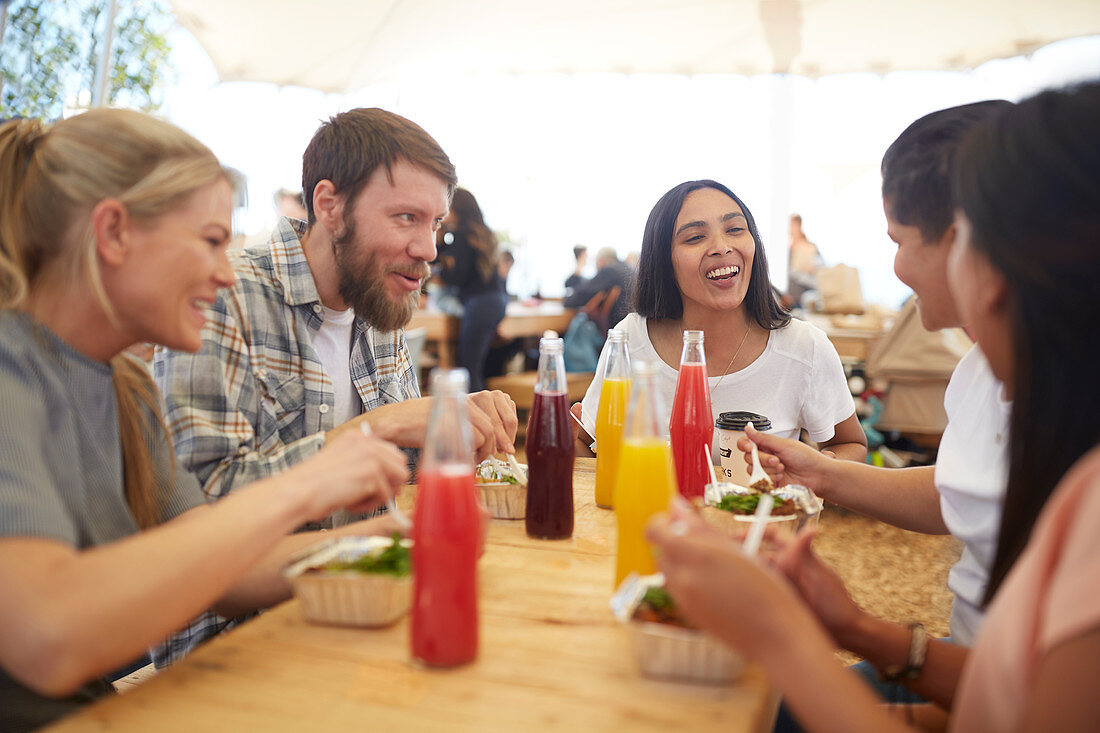 Smiling friends enjoying lunch at farmer's market