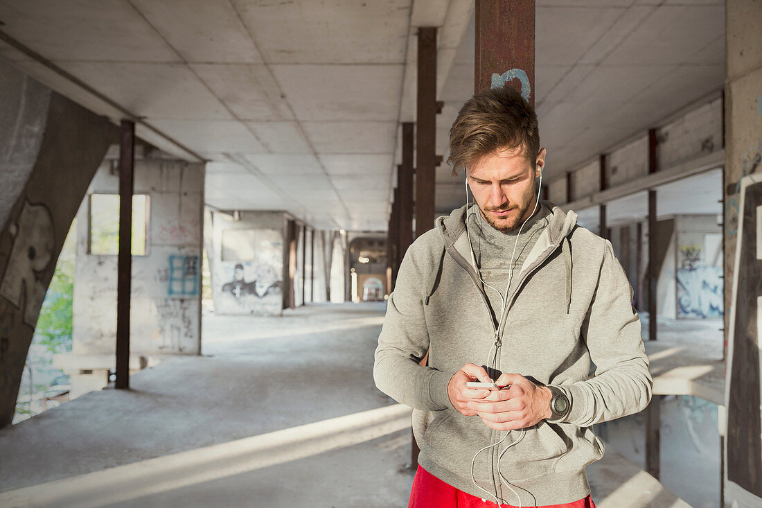 Young runner listening music with headphones