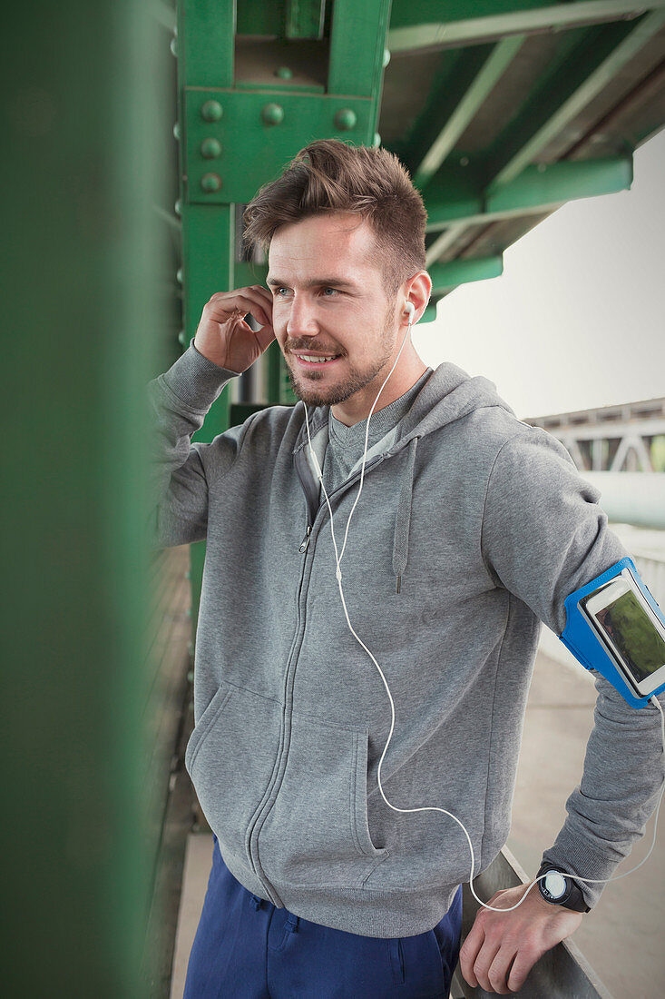Young male runner with mp3 player arm band and headphones