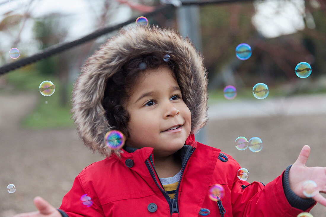 Playful toddler boy playing with bubbles