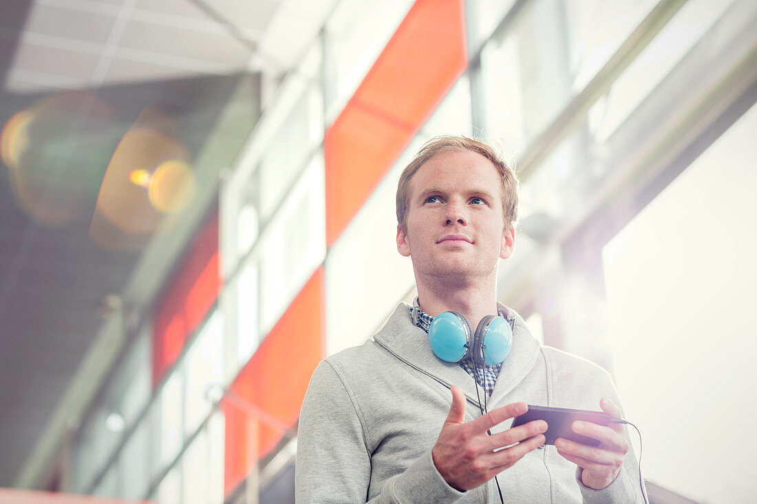 Pensive young man with headphones and mp3 player