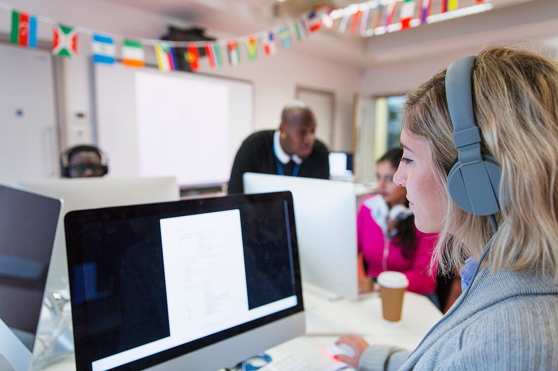 Female student with headphones using computer