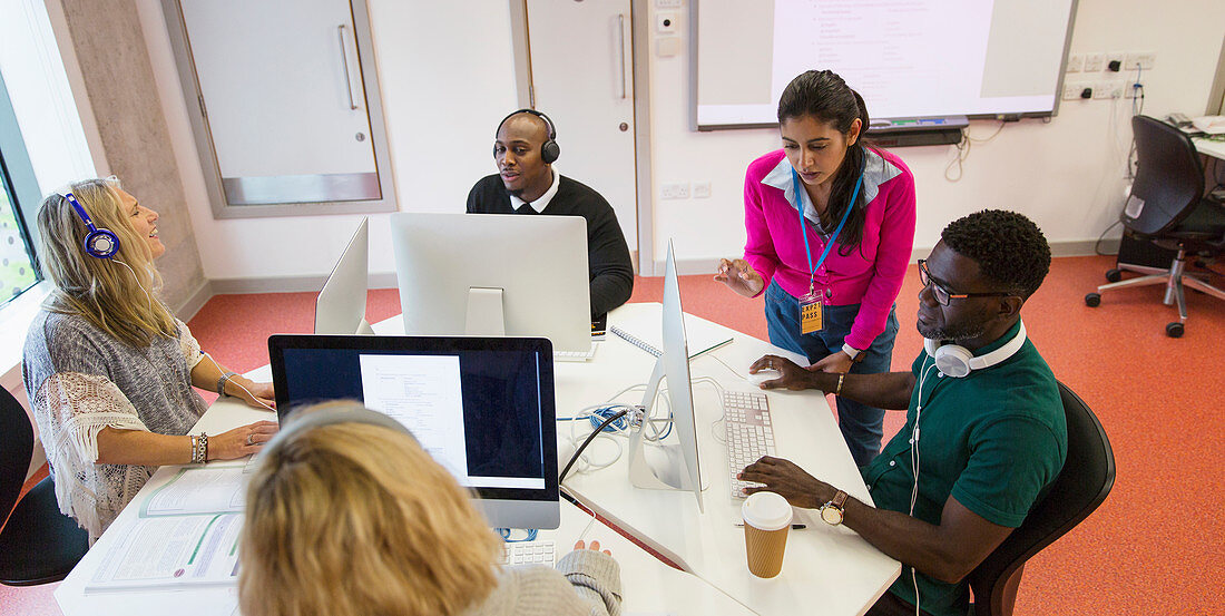 Instructor helping students in computer lab