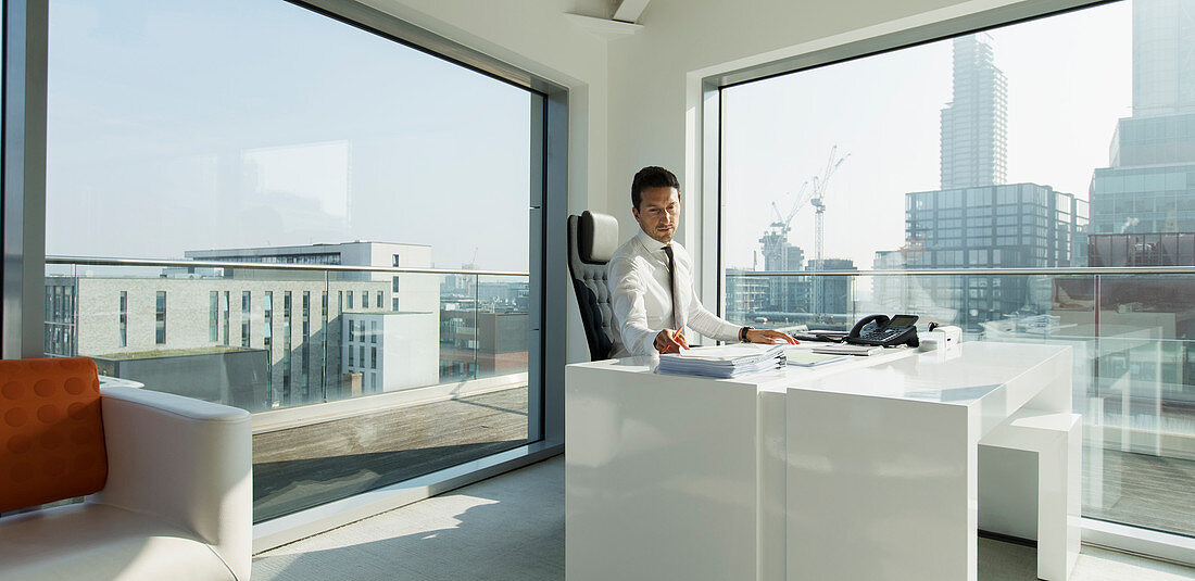Businessman working in sunny, urban office