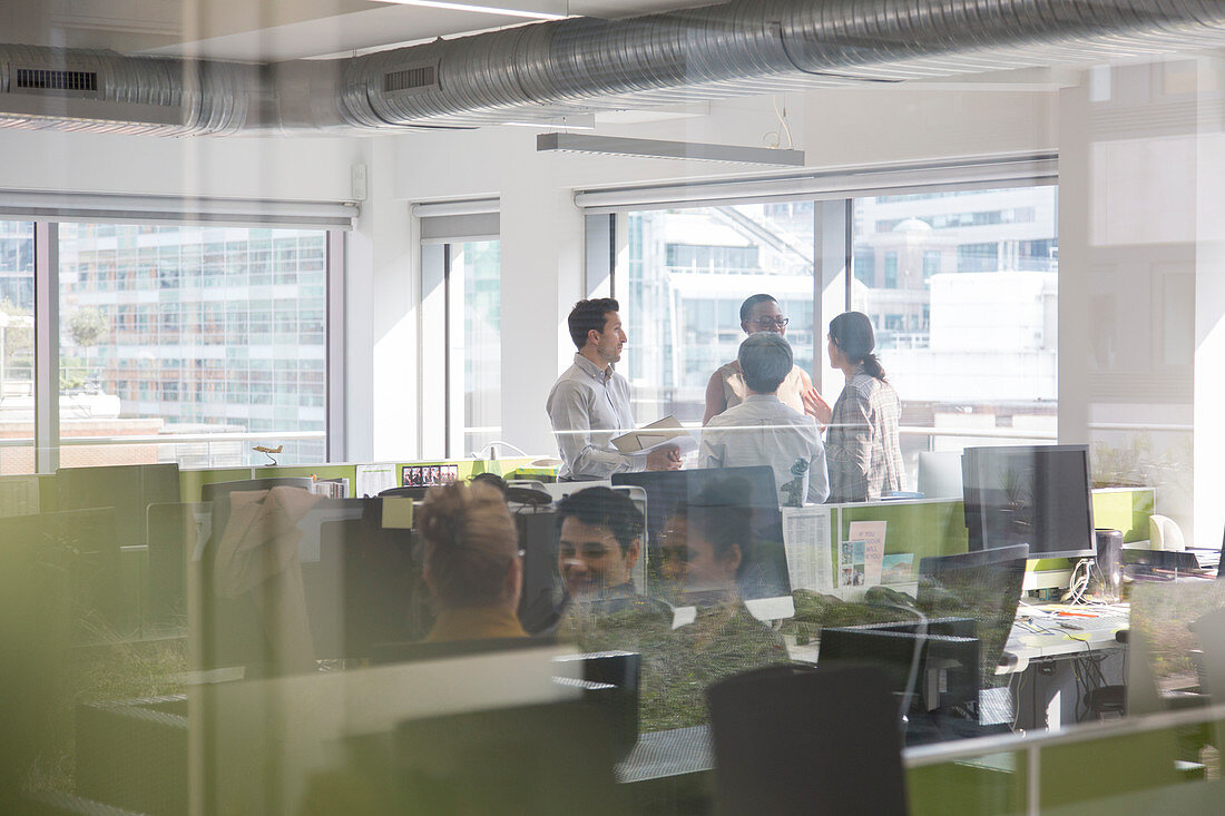 Business people talking in open plan office