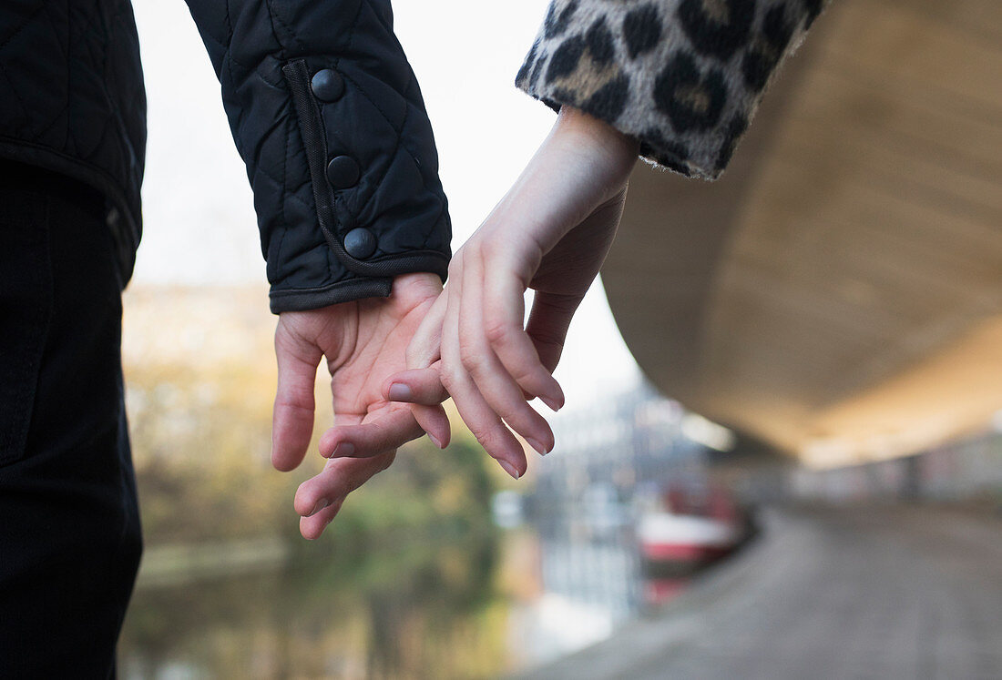 Close up young couple holding hands