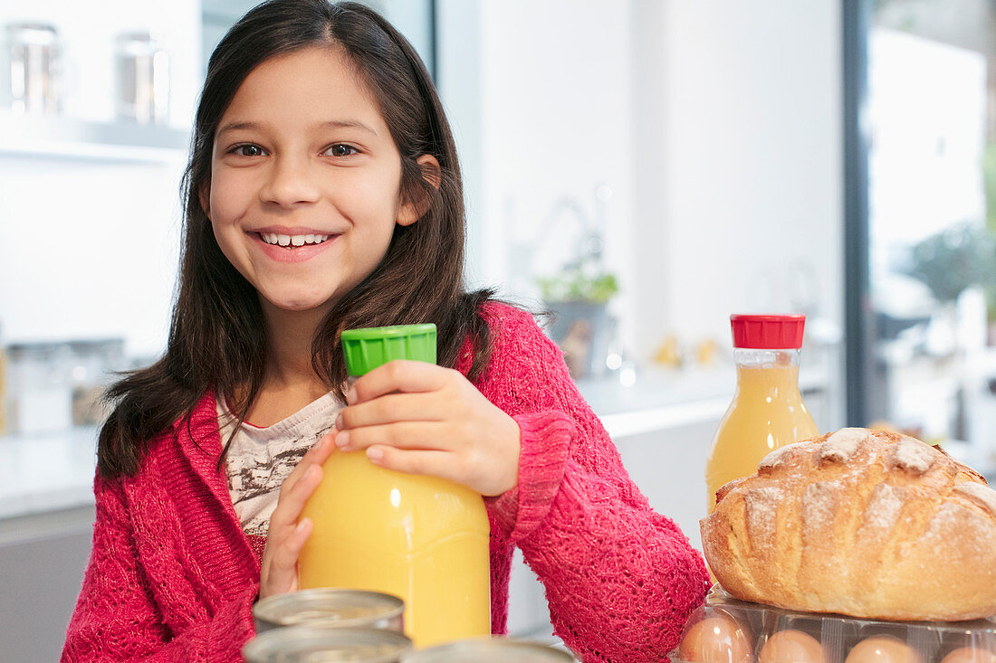 Portrait girl with orange juice in kitchen