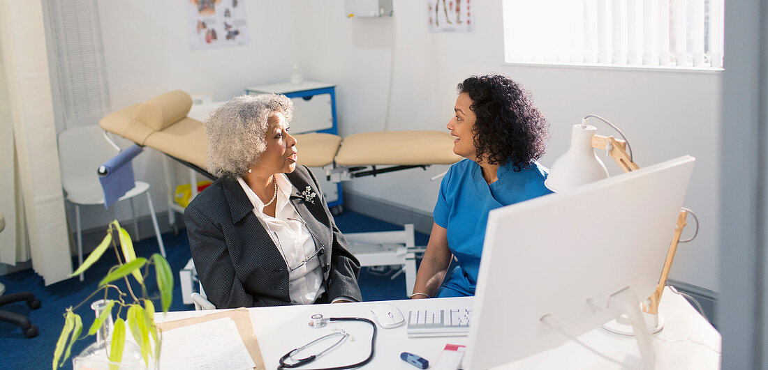 Doctor talking with senior patient in doctors office