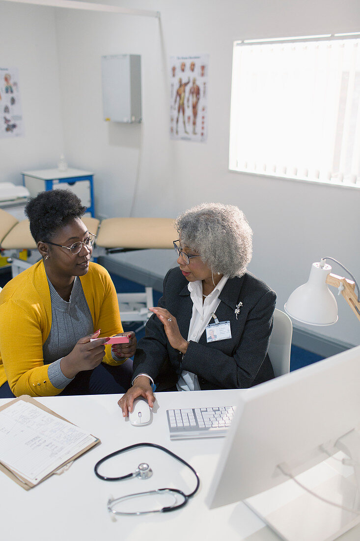 Doctor prescribing medication to patient in doctors office