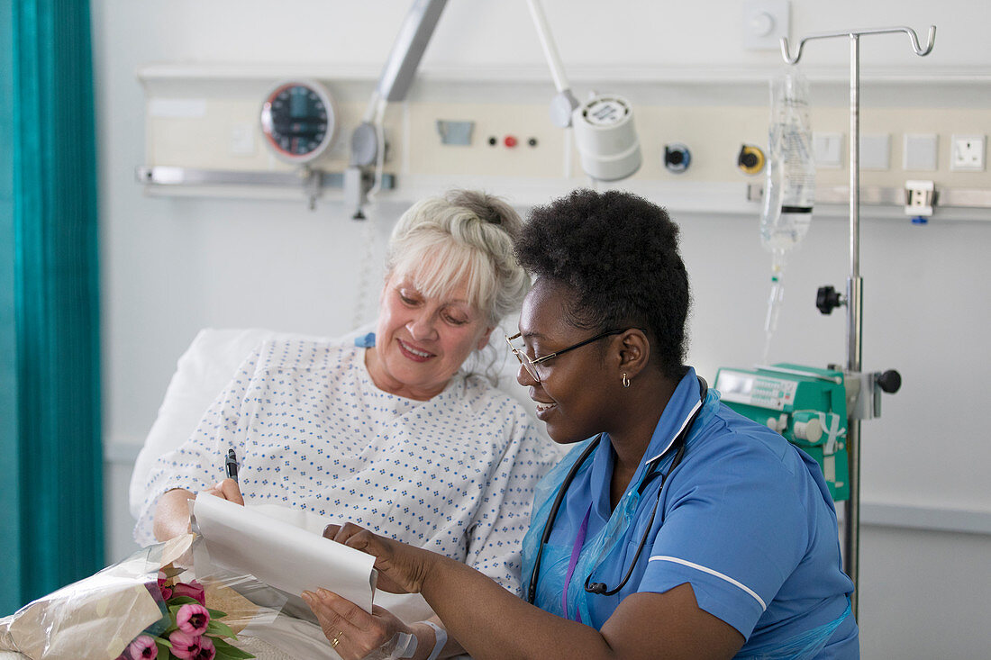 Female nurse discussing paperwork with patient