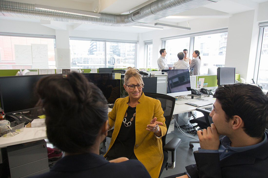 Business people talking, meeting in open plan office