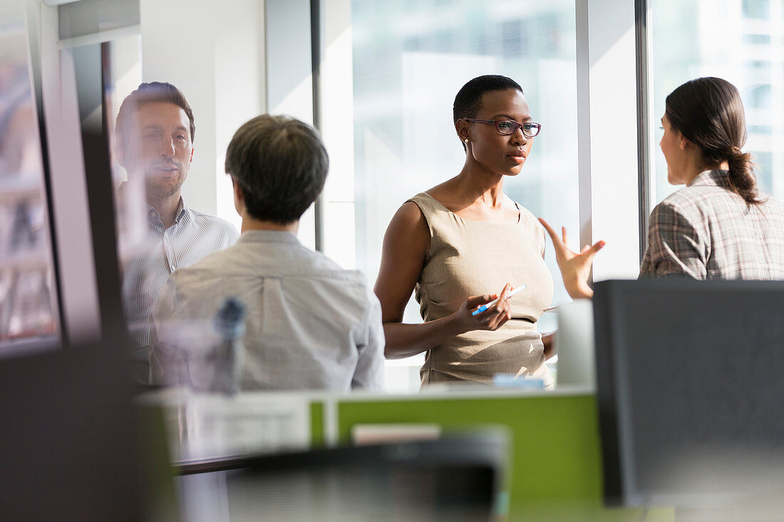 Business people talking at sunny office window