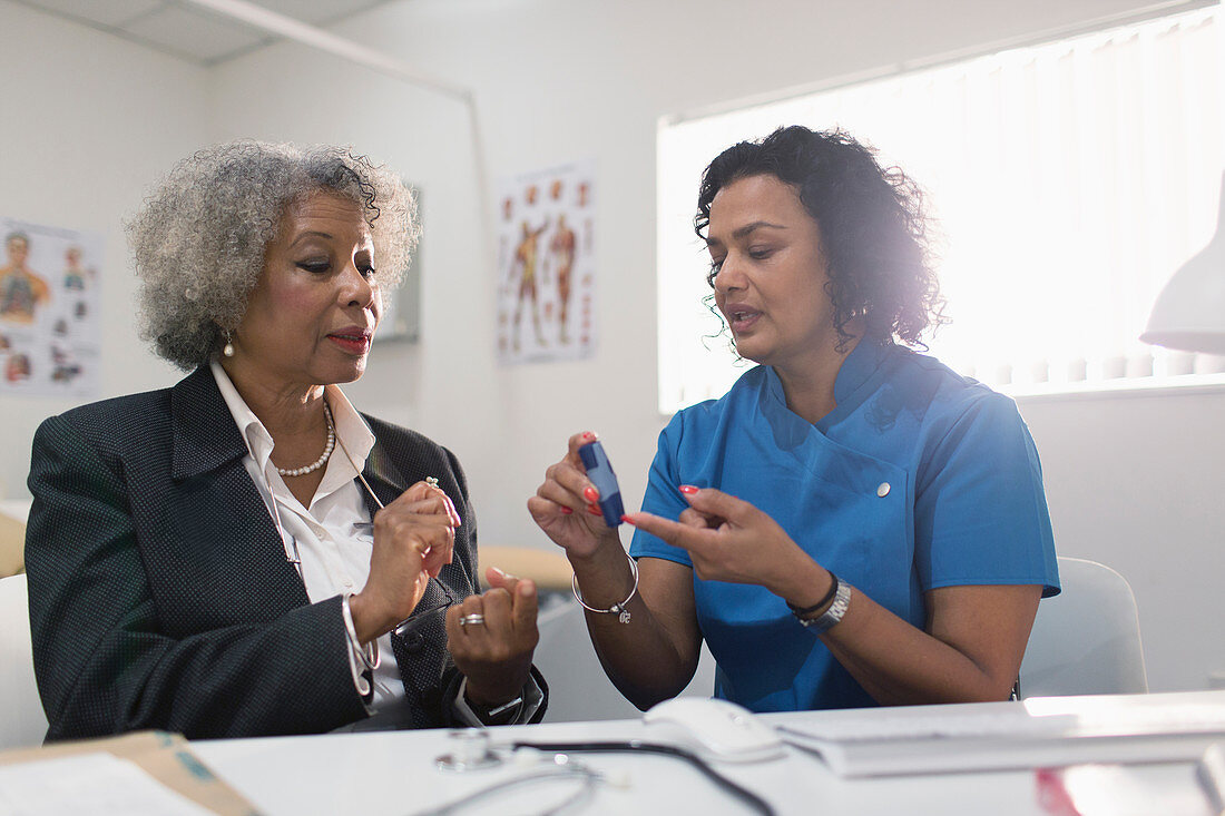 Doctor teaching diabetic patient how to use glucometer