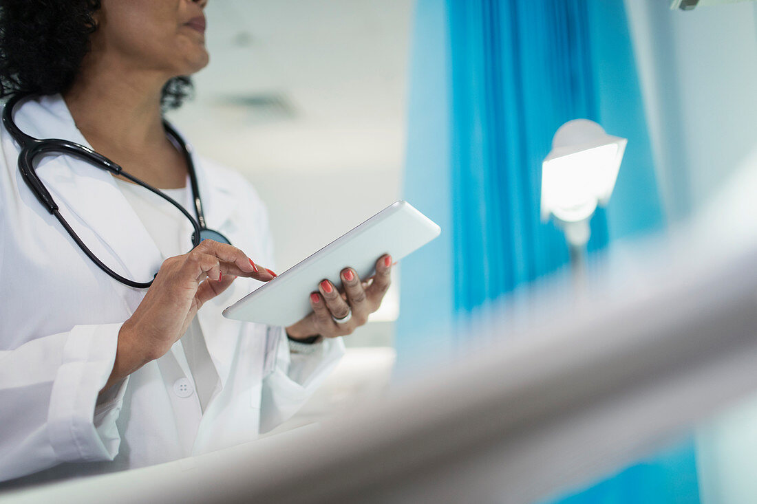 Female doctor using digital tablet in hospital room