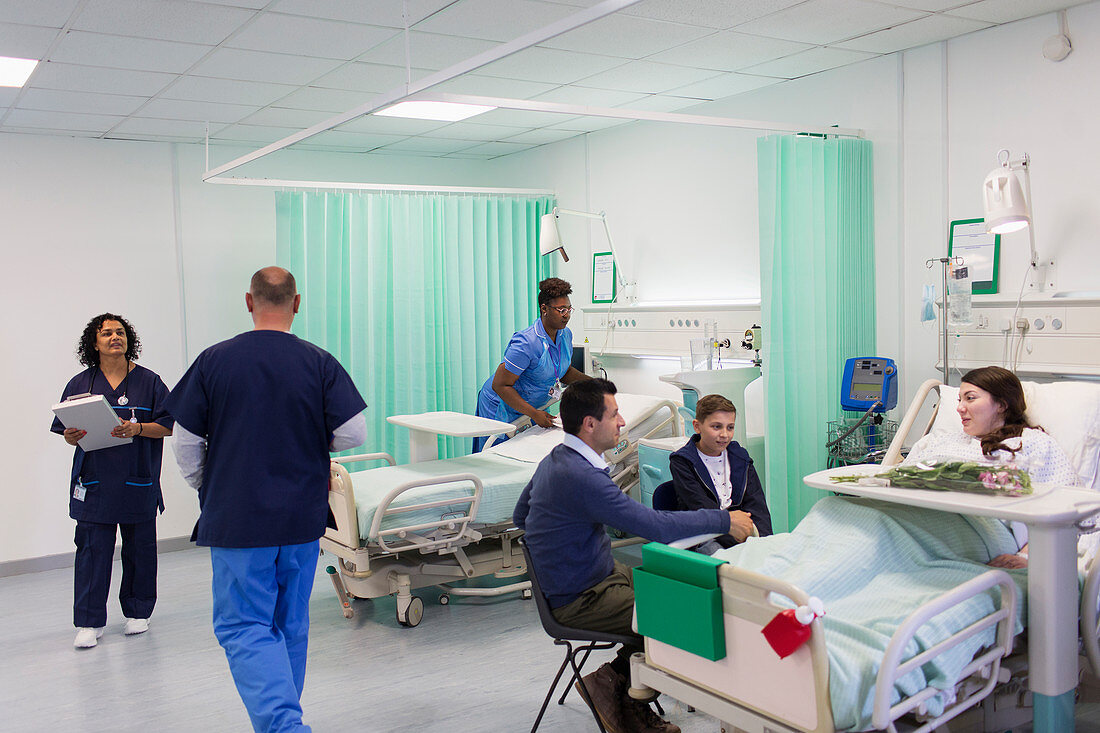 Doctors, nurses, patients and visitors in hospital ward