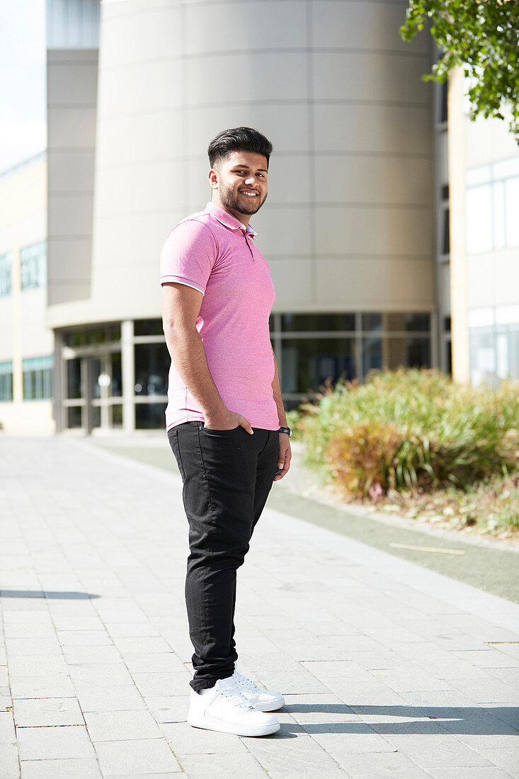 Portrait young man outside sunny building