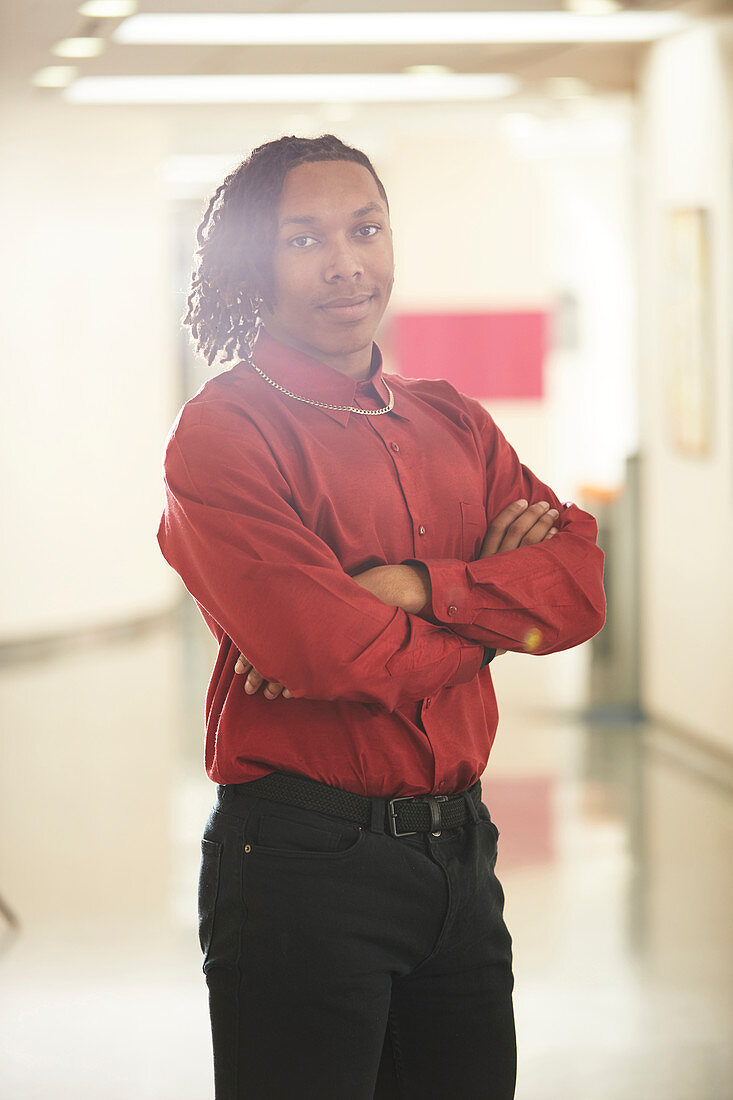 Portrait young male college student in corridor