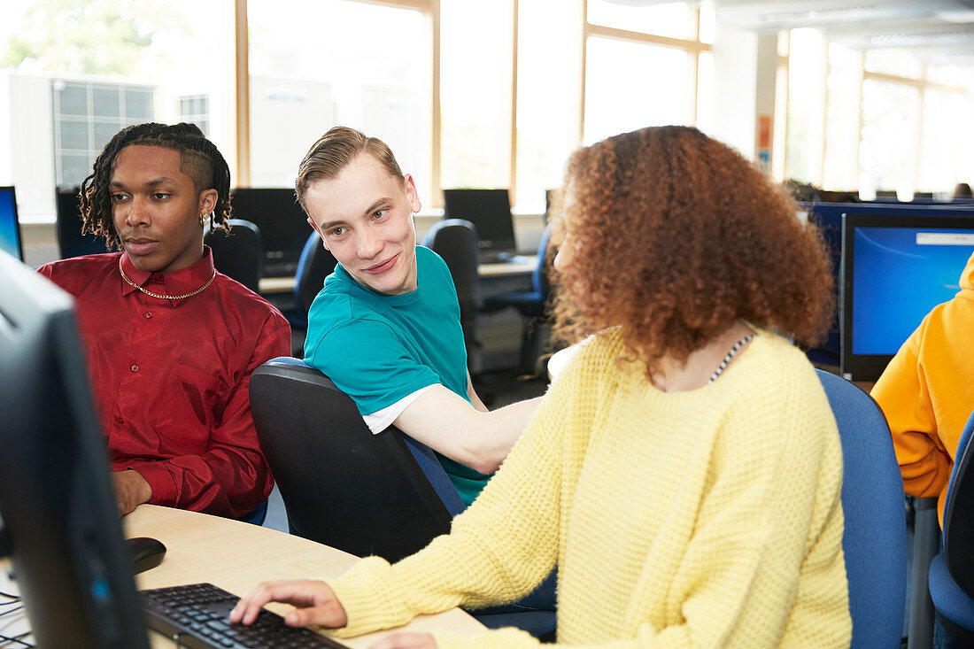 College students studying together at computers in library