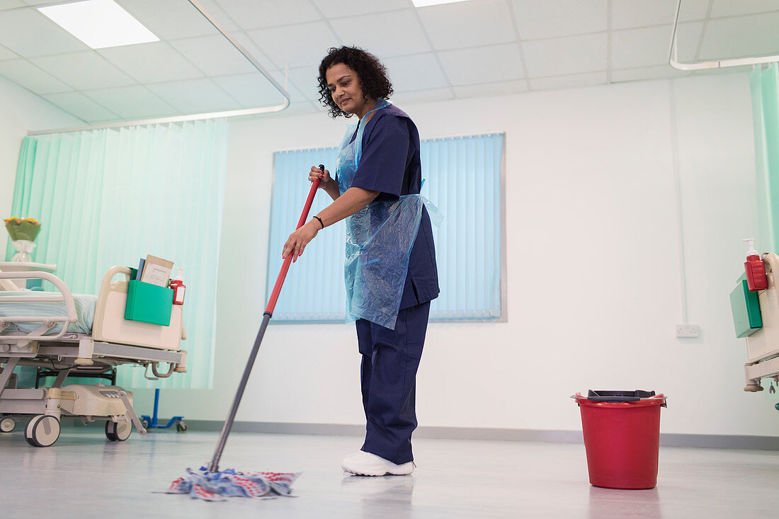 Female orderly mopping hospital ward floor