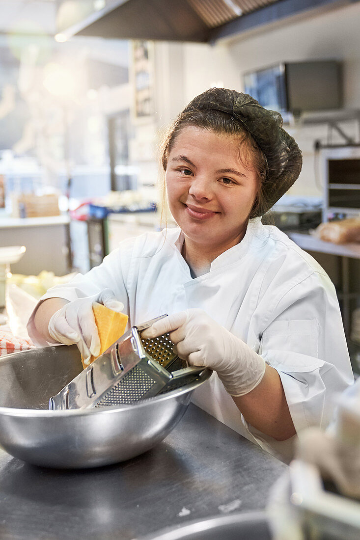 Portrait happy woman with Down Syndrome working kitchen