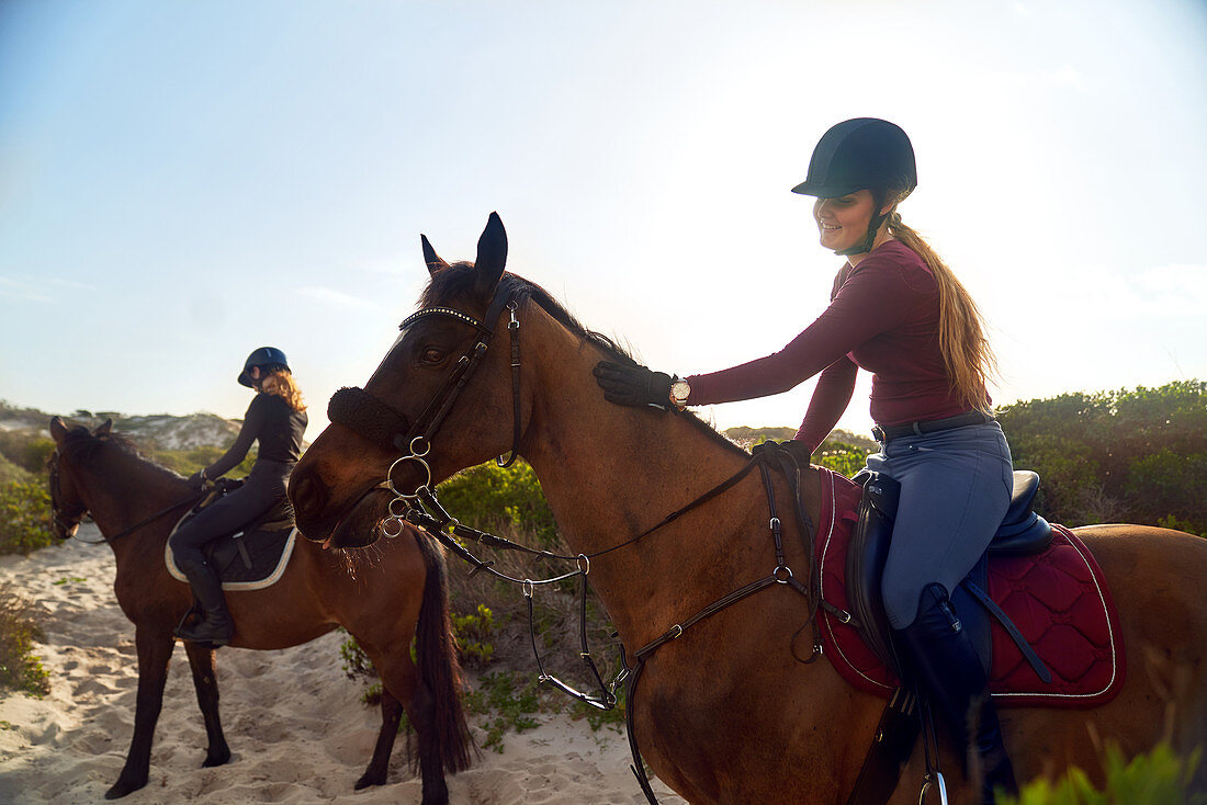Young women horseback riding on beach