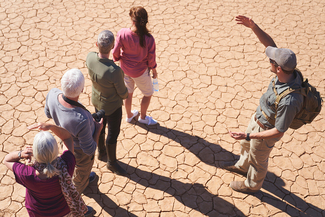Guide talking with group on sunny cracked earth
