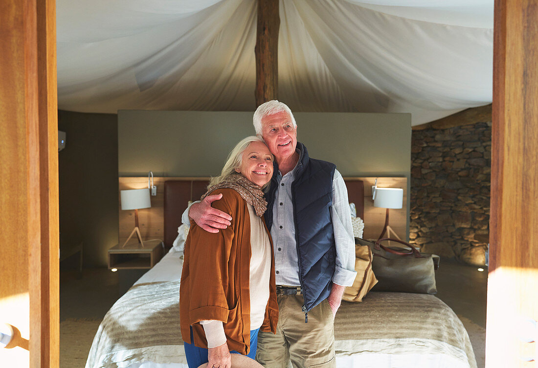 Senior couple hugging in safari lodge hotel room