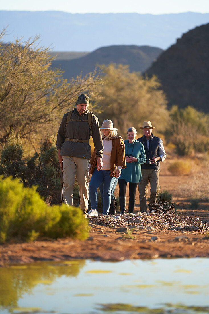 Safari tour guide leading group on sunny wildlife reserve