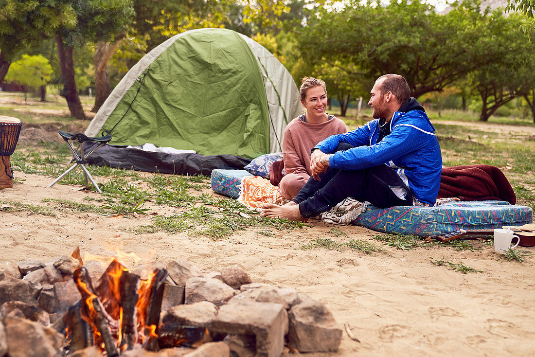 Young couple camping talking at campsite