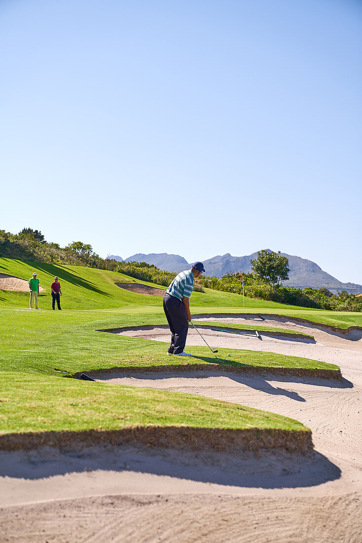 Male golfer preparing to take a shot