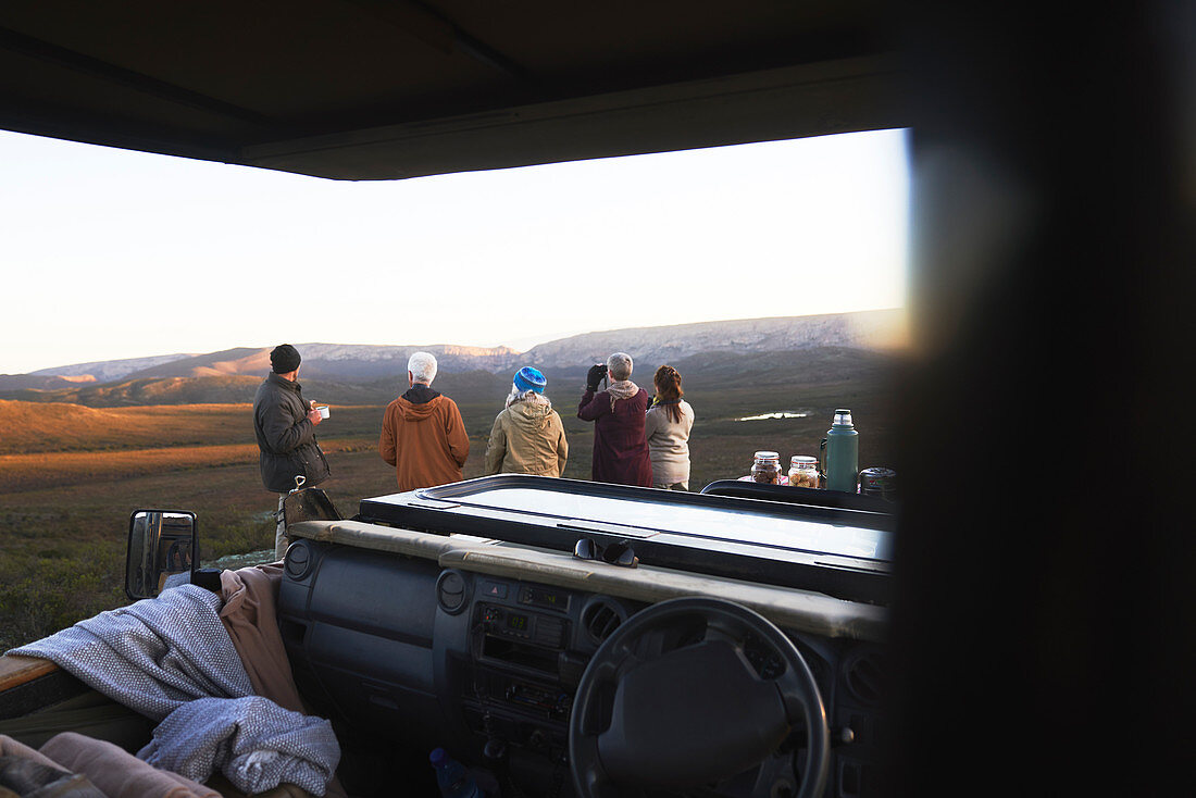 Safari group looking at landscape view outside vehicle