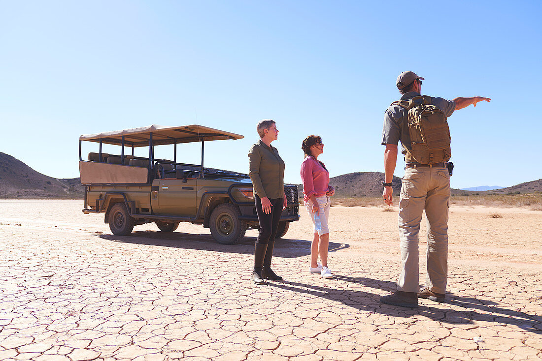 Guide talking tourists in sunny arid desert South Africa