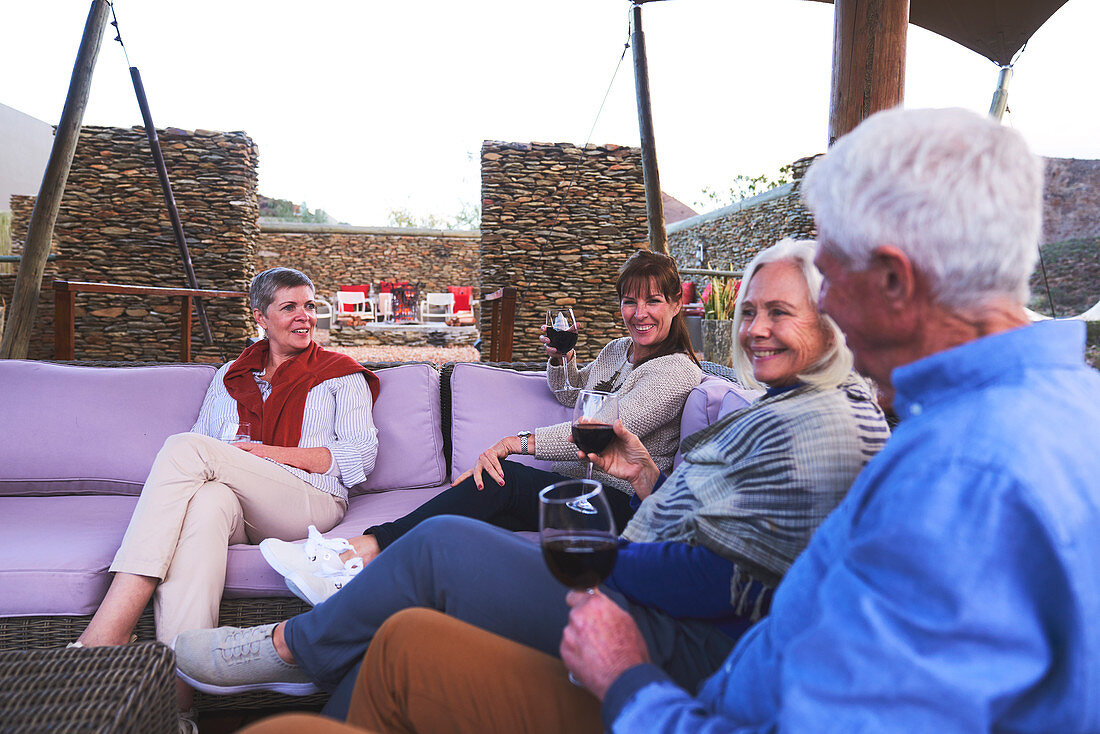 Senior friends drinking wine on hotel patio