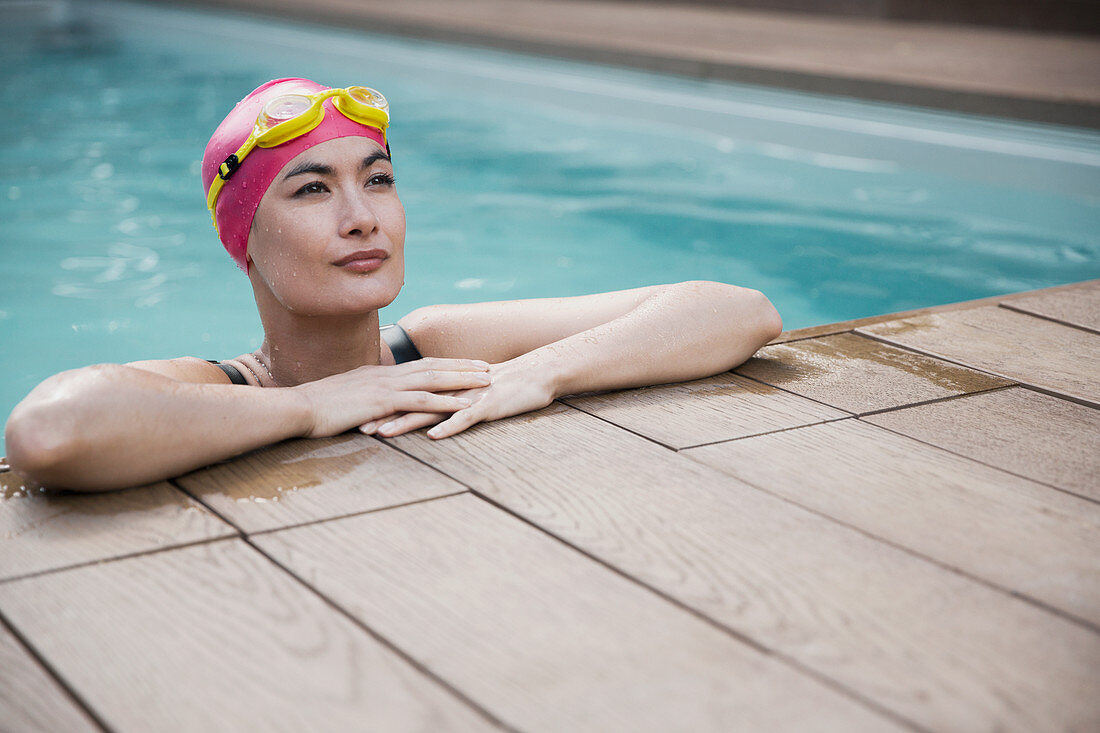 Confident woman in swimming cap and goggles