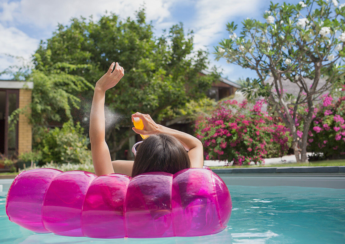Woman applying sunscreen on inflatable raft