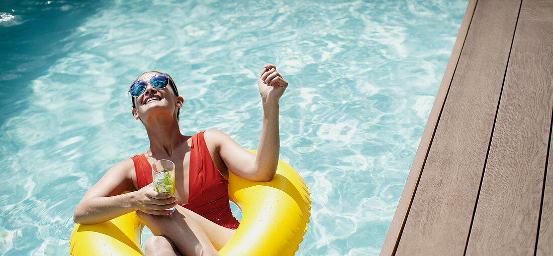 Woman with inflatable ring drinking cocktail
