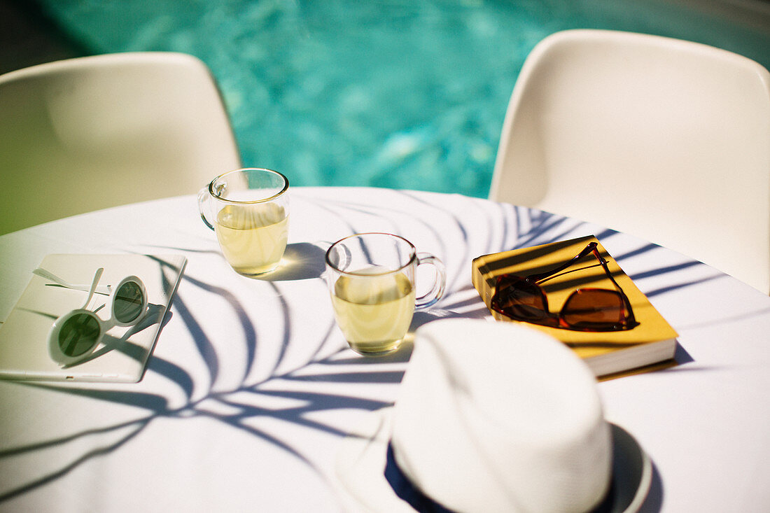 Tea and sunglasses on poolside table