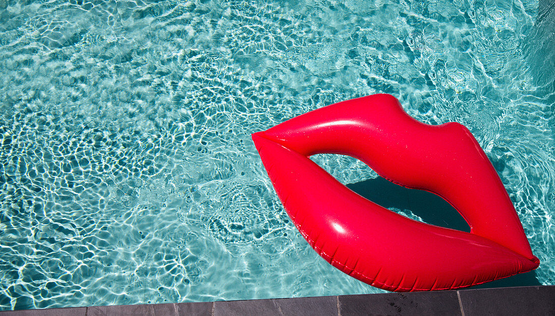 Inflatable lips floating in summer swimming pool
