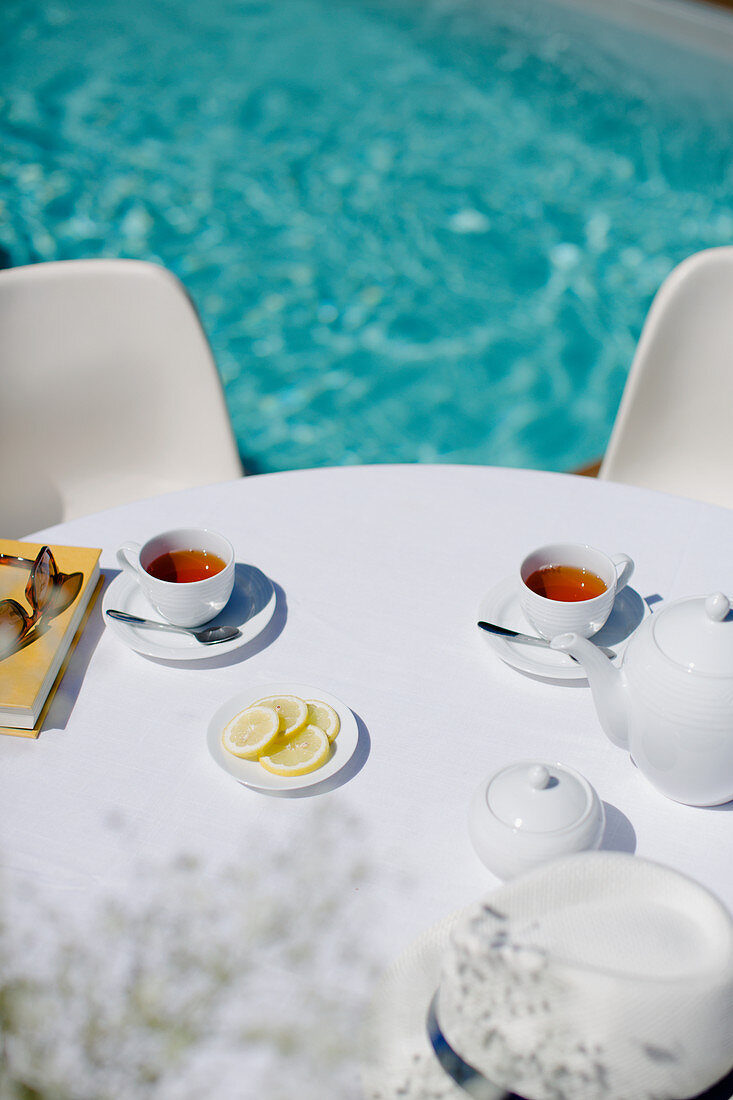 Tea service on summer poolside patio table