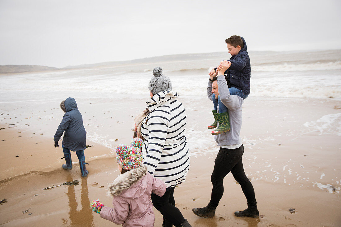 Family walking on winter ocean beach