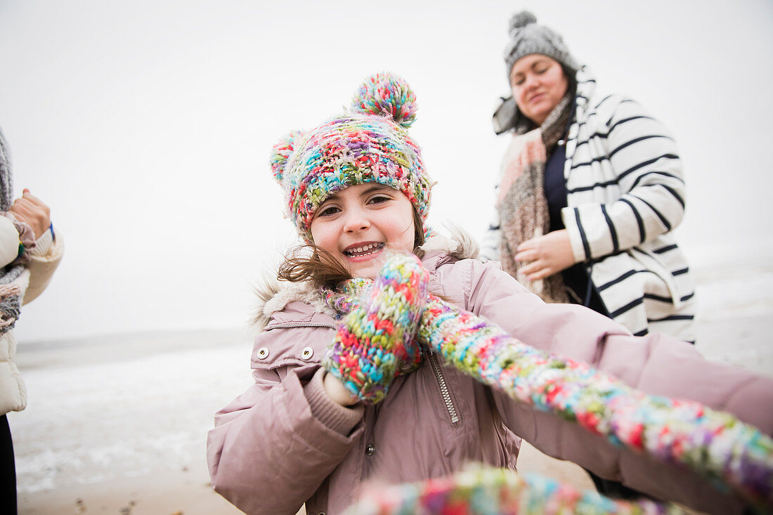 Carefree girl in warm clothing on winter beach