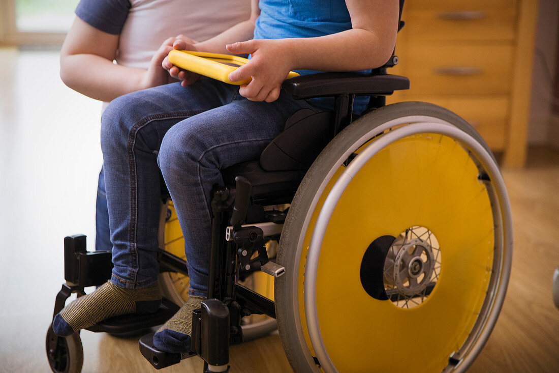 Boy in wheelchair using digital tablet