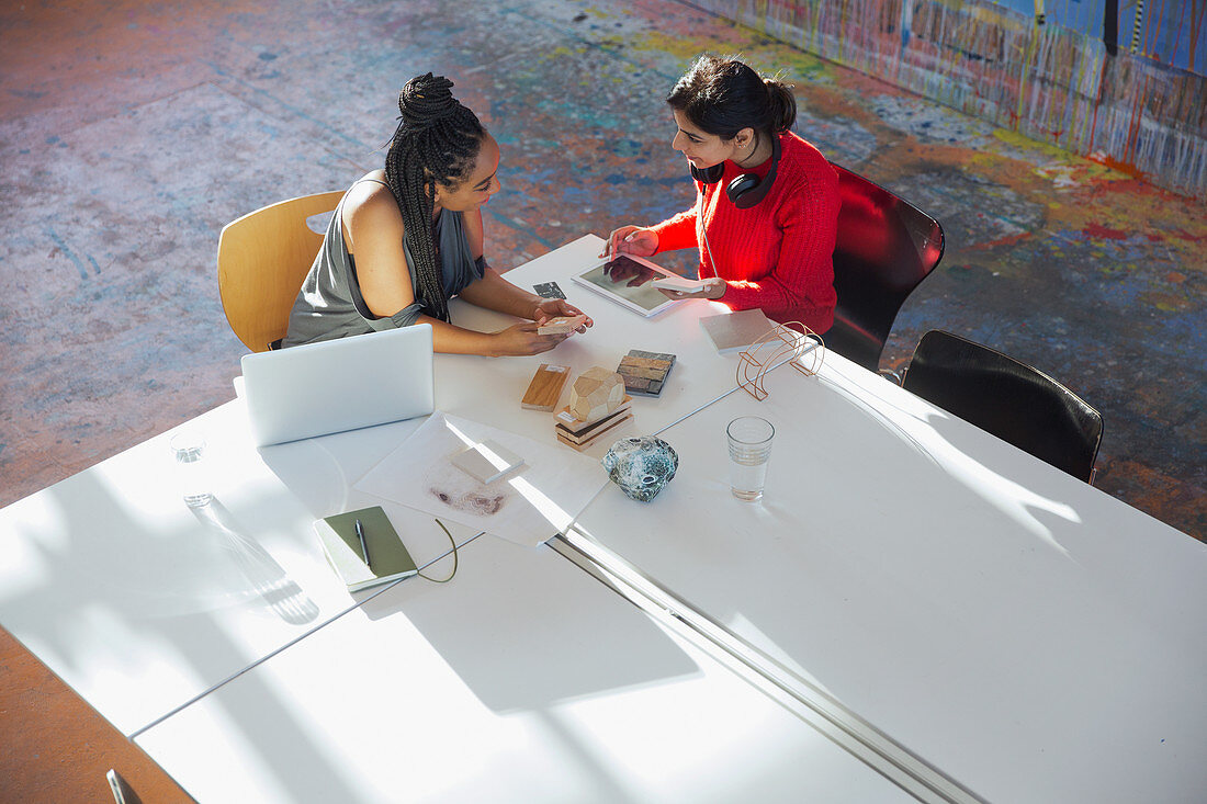 Businesswomen talking, using digital tablet