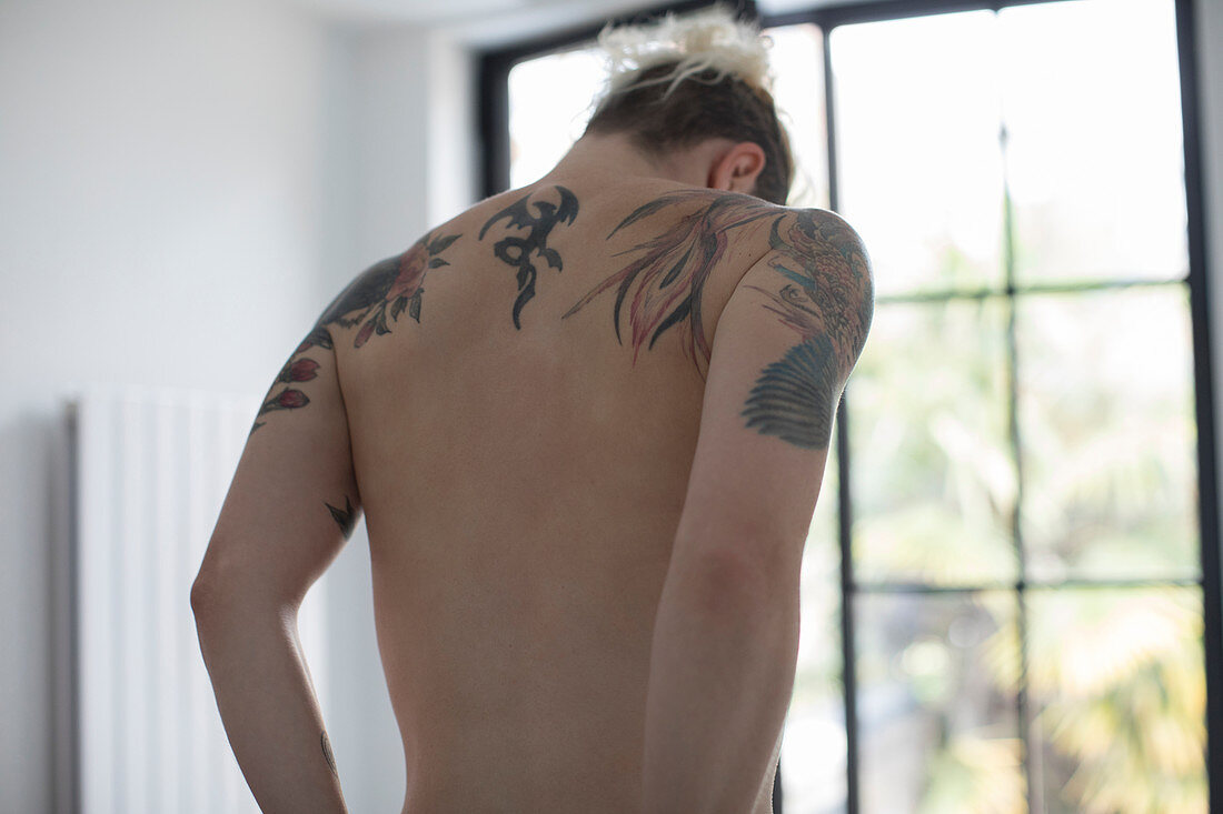 Tattoos on bare back of sensual woman