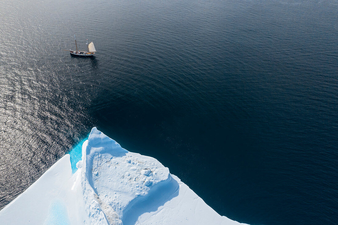 Ship sailing past iceberg on Atlantic Ocean Greenland
