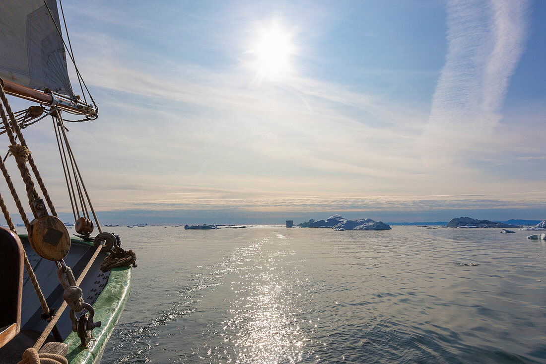 Sailboat on Atlantic Ocean with melting icebergs Greenland
