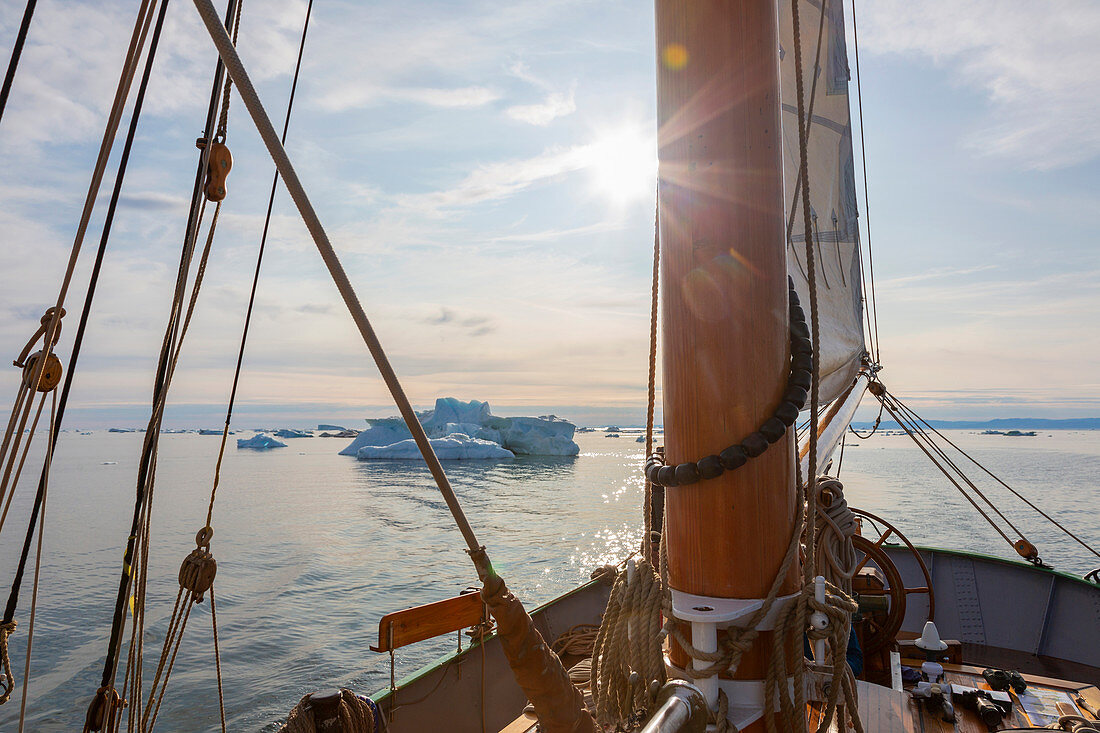 Ship sailing toward icebergs on tranquil