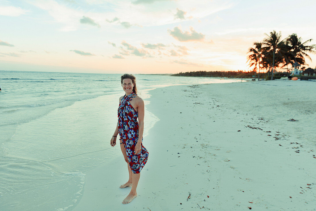 Woman in sun dress on tranquil tropical ocean beach Mexico