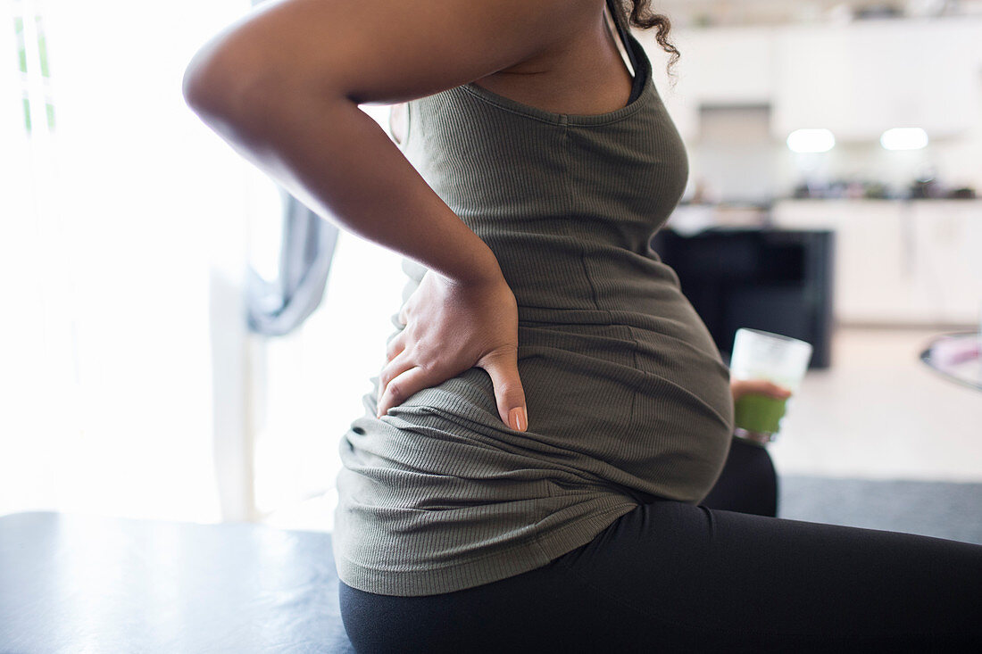 Close up pregnant woman rubbing aching back